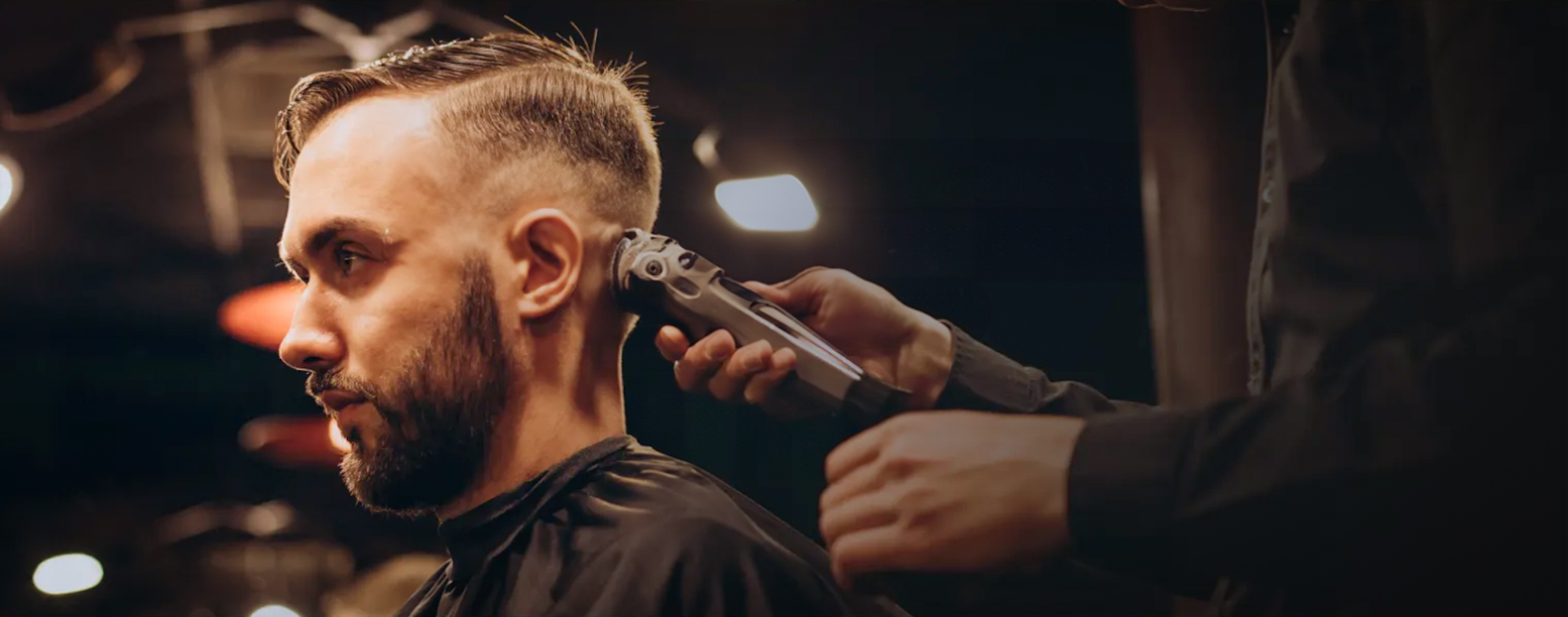 Professional barber cutting client's hair in barbershop